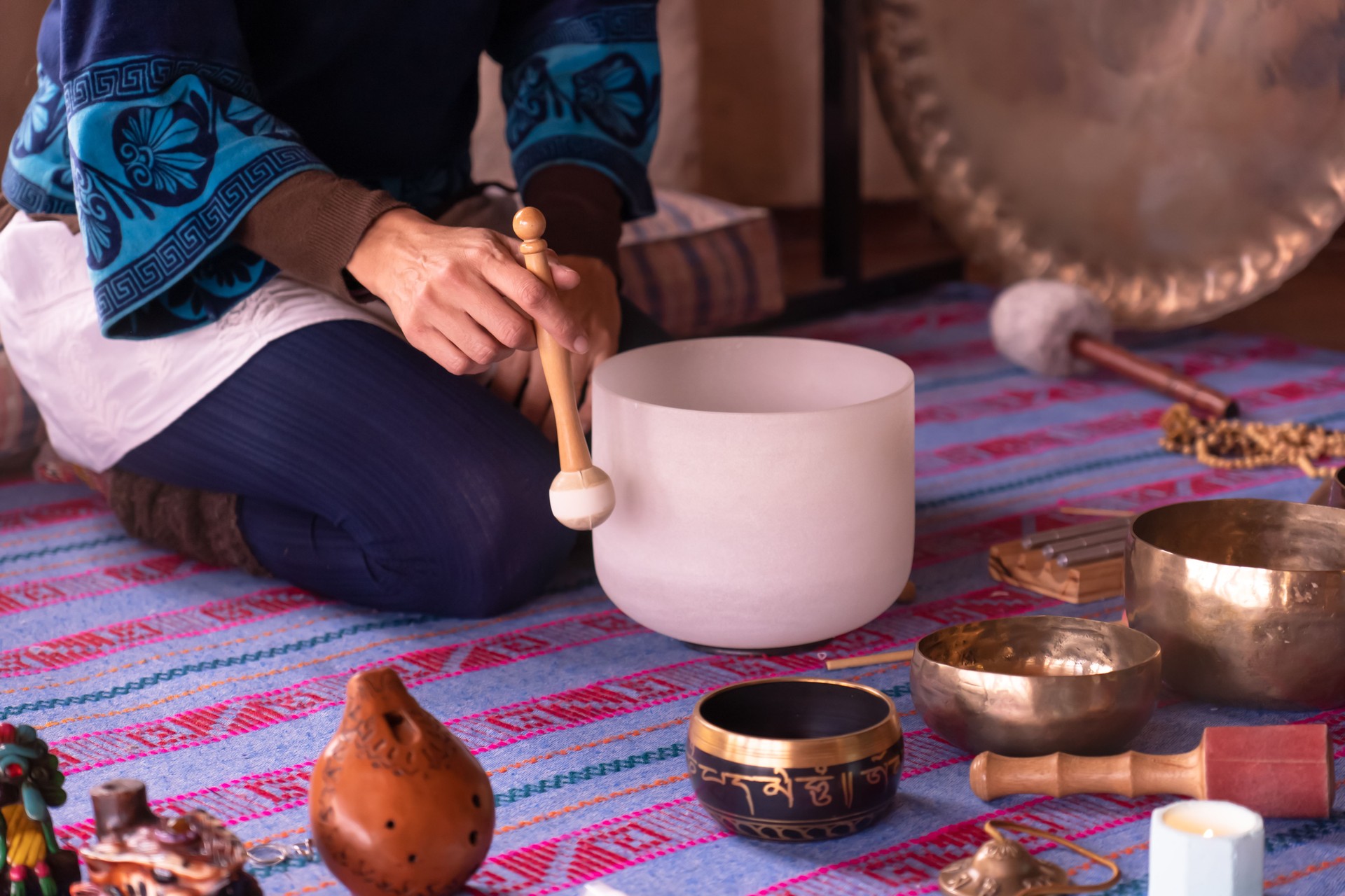Close-up of a woman's hands playing a quartz singing bowl.